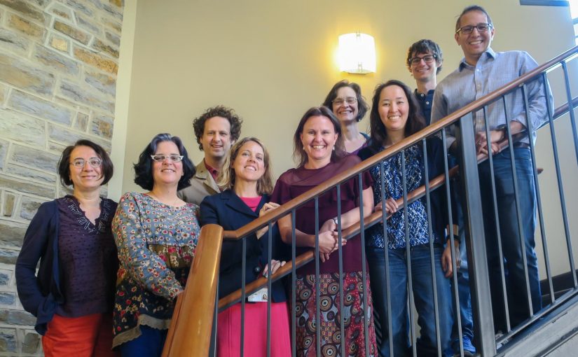 group of nine faculty on stairs