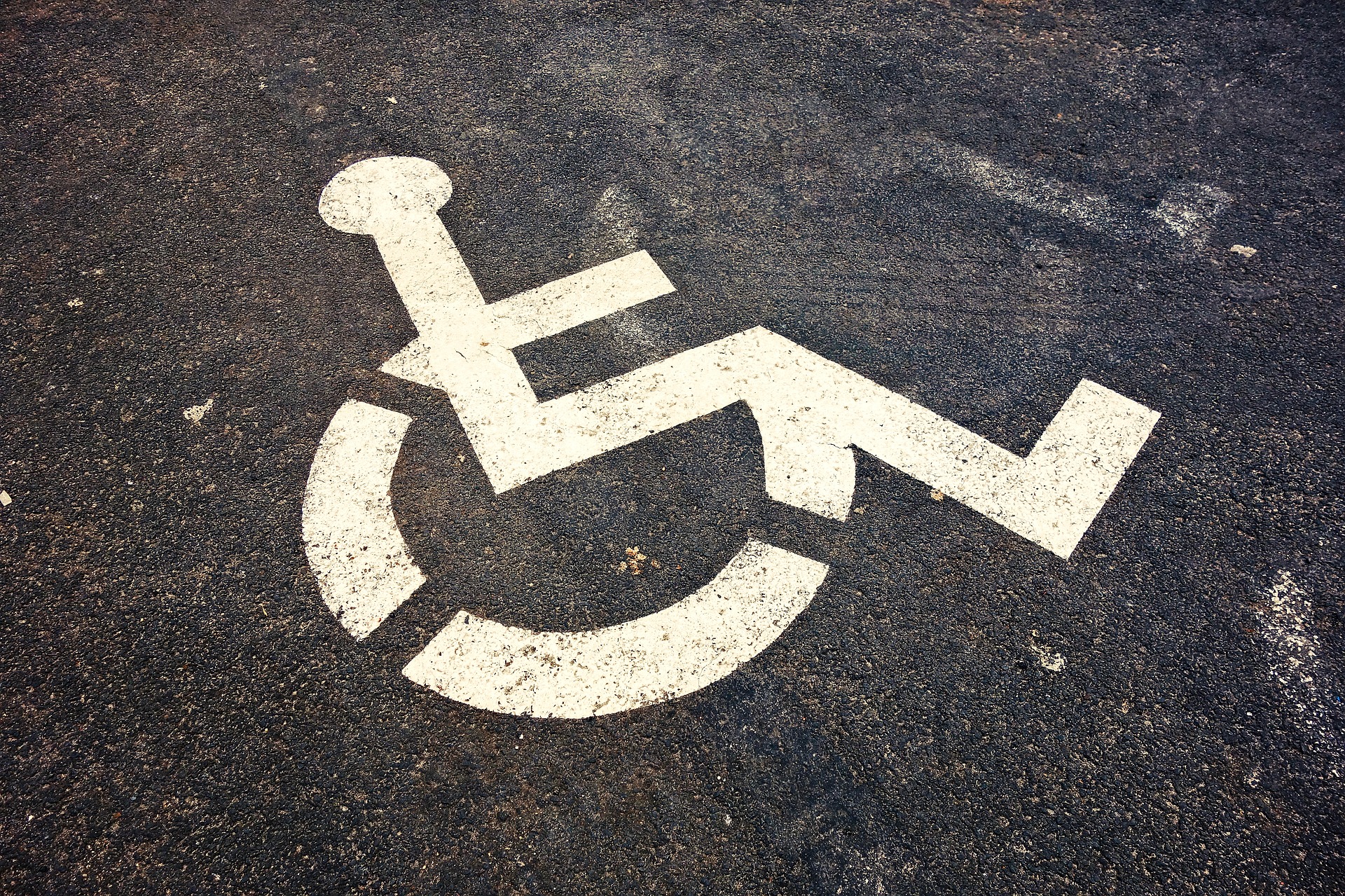 image of wheelchair accessibility icon on pavement.