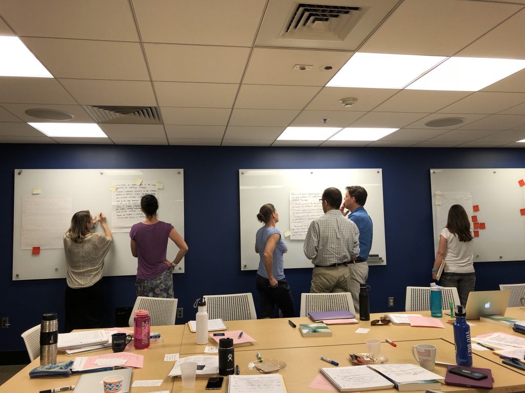 faculty participants doing a group activity at whiteboards