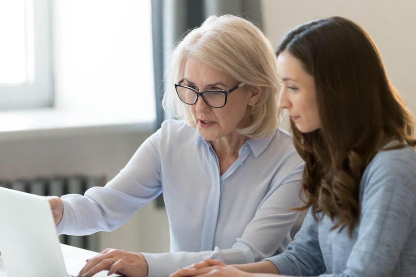 Two women looking at a laptop together.