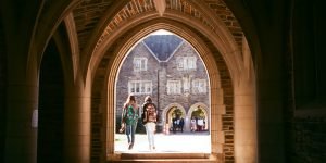 Students walking through archway on Duke campus