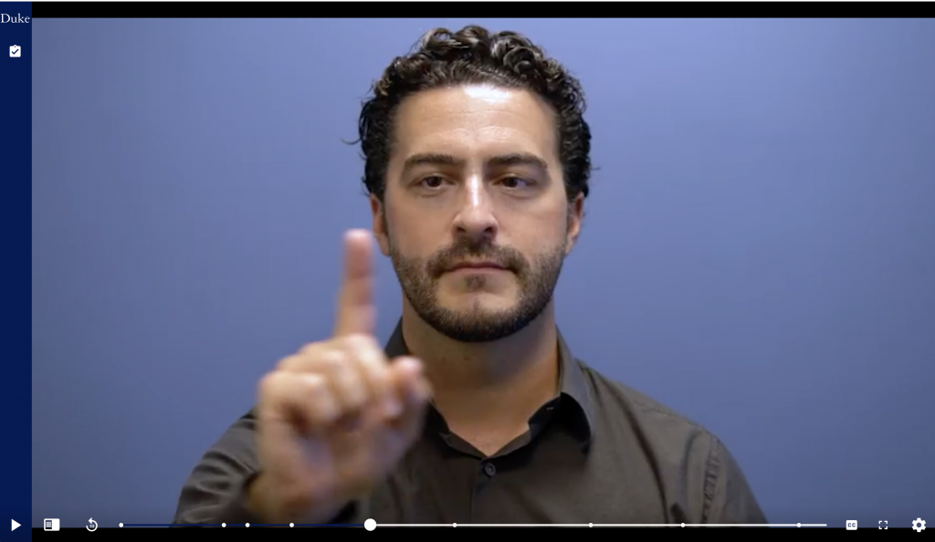 Nick Hudak holds his index finger in his eyeline to demonstrate how to test for extraocular weakness in the neurology telehealth module. 