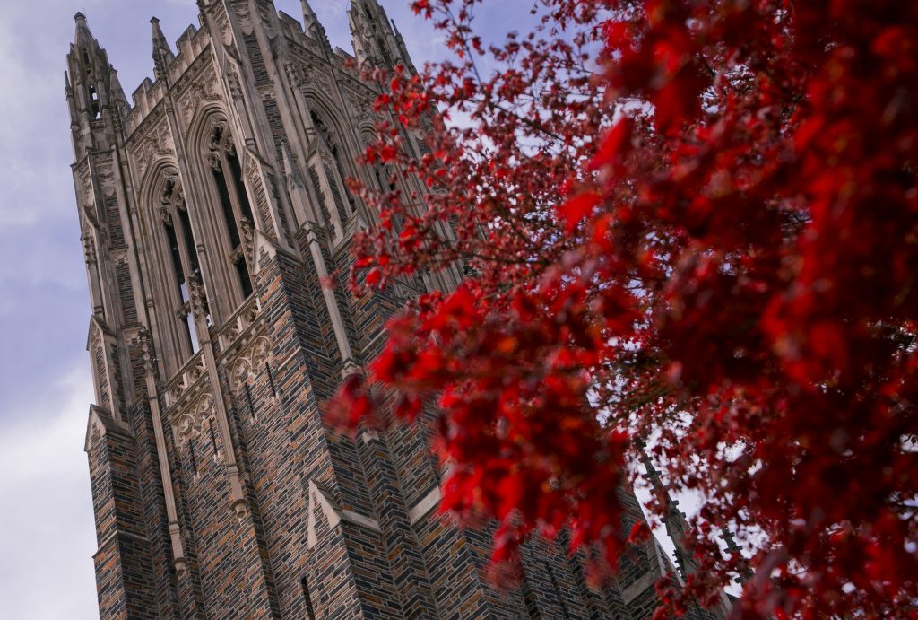 The Duke chapel with a red tree in front of it.