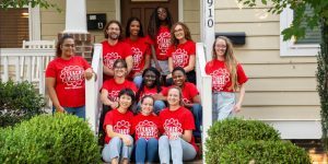 A group of TeachHouse fellows posing together on the front porch of a house